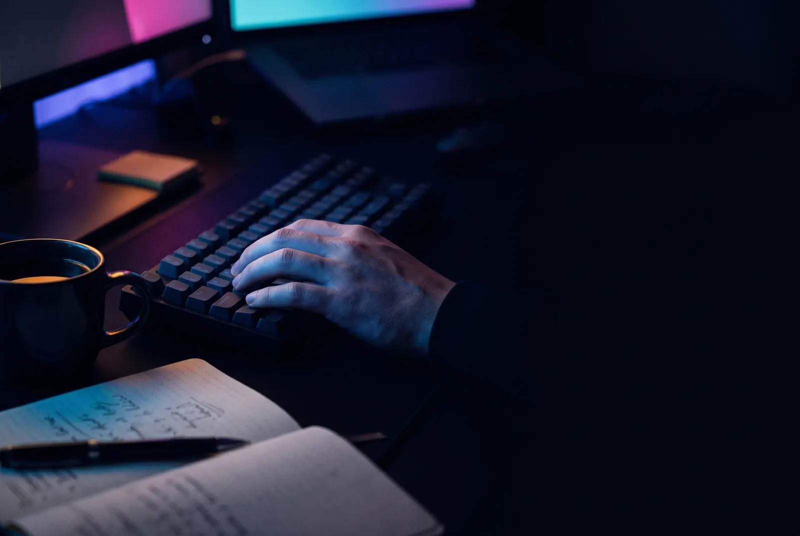 A desk at 11pm with dashboards across multiple monitors